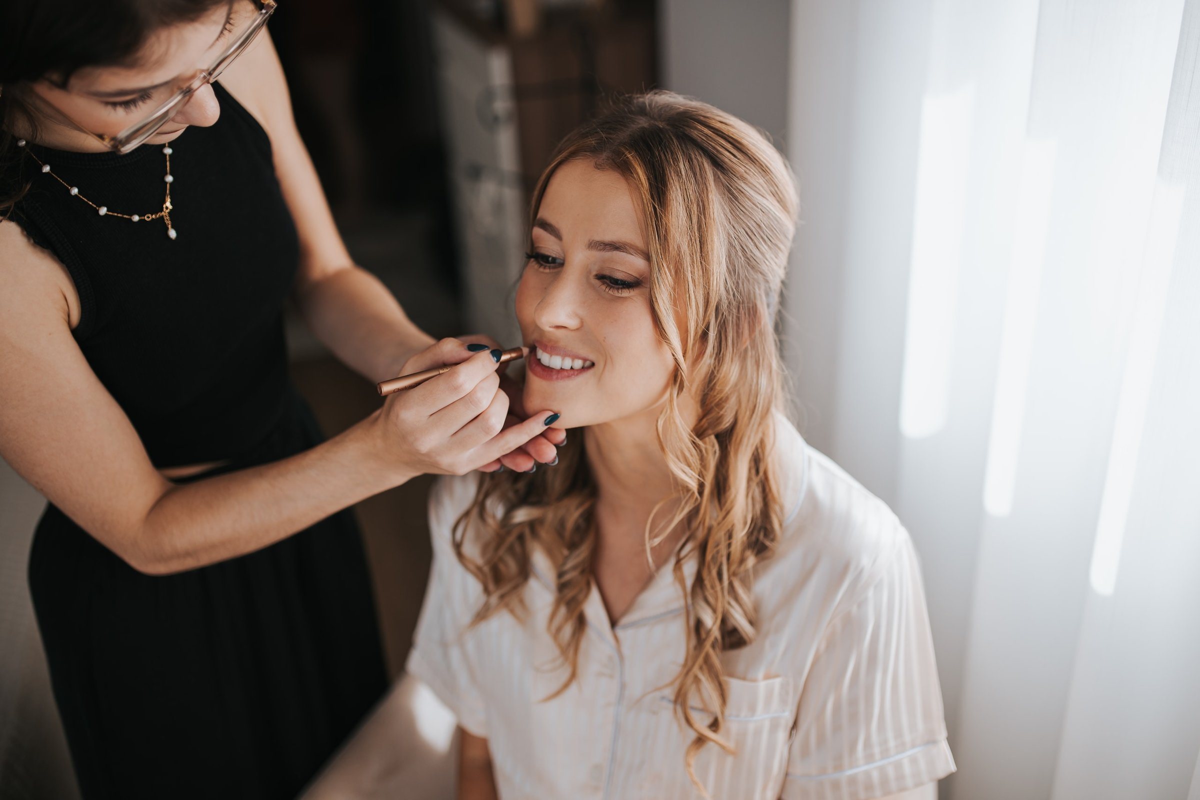 Bárbara Santos lining a bride's lips on her wedding morning